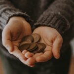 copper-colored coins on in person's hands